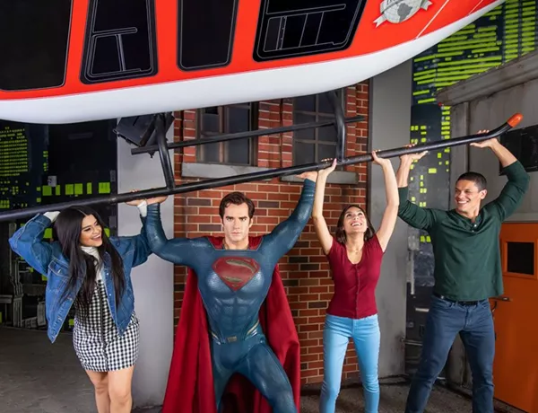 Tourists interacting with Superman wax figure at Madame Tussauds.