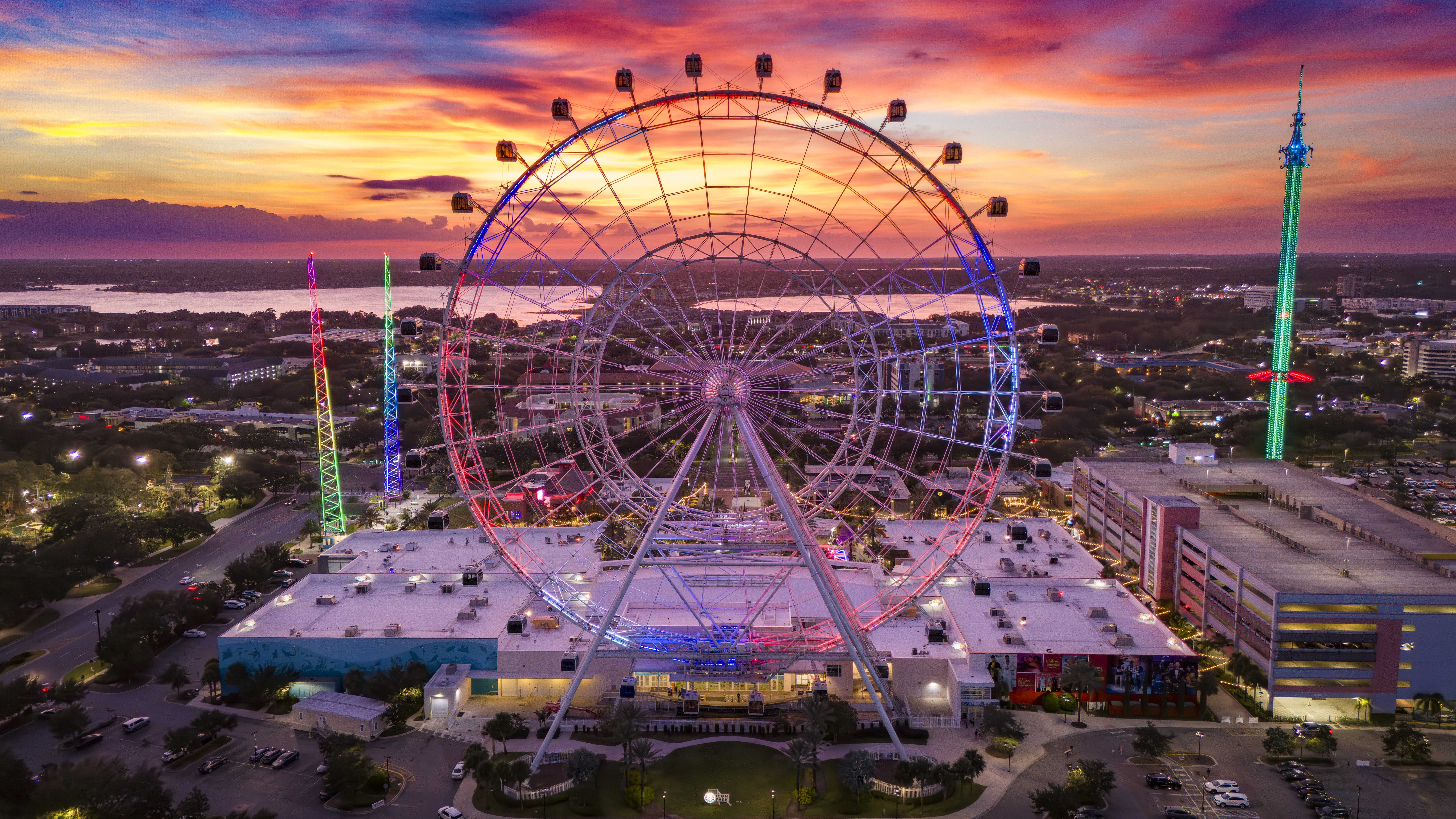 View of the entirety of The Orlando Eye during dusk with additional Icon Park attractions also shown. 